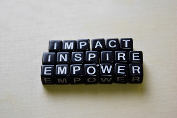 Impact - Inspire - Empower on wooden blocks. Business and inspiration concept