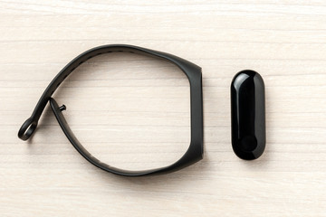 black smart fitness sport tracker at wooden background. close up. gear for health care