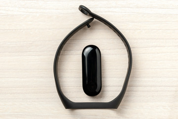 black smart fitness sport tracker at wooden background. close up. gear for health care