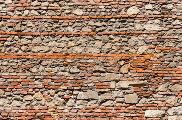 Composite old stone and bricks wall with rough surface as background