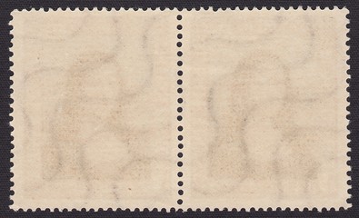 The reverse side of two postage stamps with remnants of glue and female profile