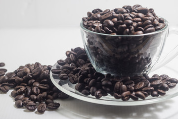 Coffee beans on glass cups are arranged in the middle and right, and close-up photography on a white background.