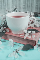 tea cup composition, book, apple blossom branch