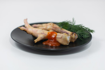 Grilled chicken legs on a black plate