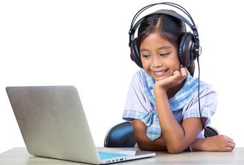 An isolated image of schoolgirl, wearing headphones, listening to music from the computer happily