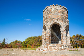 Observation tower at the peak of Mount Battie in Camden, Maine, USA. Sunny, autumn day with bright blue sky background.  
