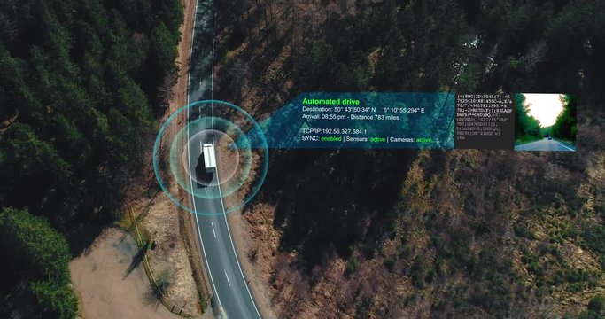 Helicopter shot of self Driving trucks driving on a forest highway with technology assistant tracking information, showing details. Visual effects clip