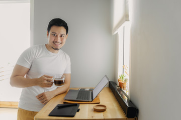 Happy freelancer man is working on his laptop. Concept of freelance creative works.