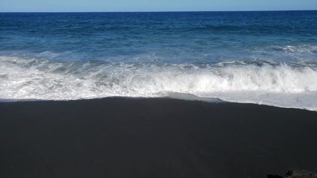 waves breaking on black sand beach in hawaii captured in slow motion. part 1 of 2