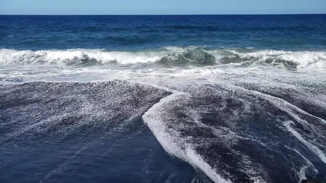 waves breaking on black sand beach in hawaii captured in slow motion. part 2 of 2