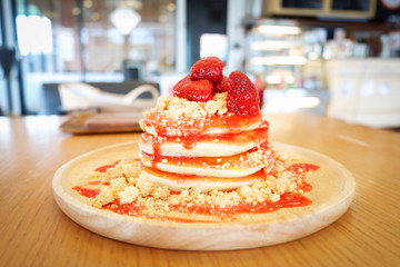 Pancakes strawberry fruit and sauce on wooden background in the cafe cake and coffee shop