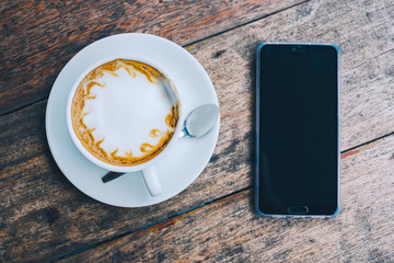 cup of coffee tablet and smart phone on wooden table