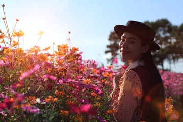 silhouette portrait lady in flower field at sunrise,caucasian woman with pink cosmos flowers,woman wearing dress relaxing and happy with smelling flower in garden,female in park with on holiday