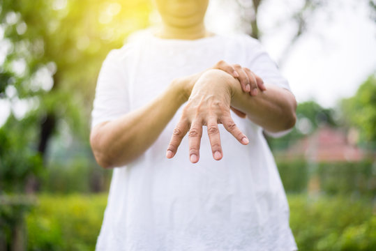 Elderly asian women suffering with parkinson's disease symptoms