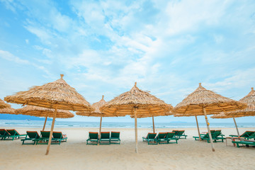 Fototapeta na wymiar White sand beach with relaxing chairs