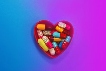 medical capsules in a heart shaped container.