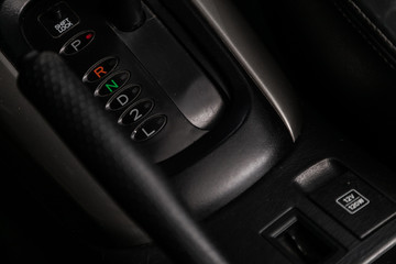 Сlose-up of the car  black interior:  dashboard,  accelerator handle, seats and other buttons.