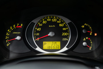 Сlose-up of the car  black interior:  dashboard, speedometer and tachometer with green backlight...
