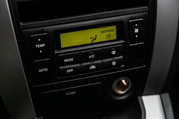 Сlose-up of the car  black interior:  dashboard, adjustment of the blower, air conditioner and other buttons.