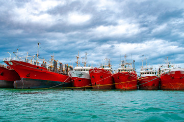 Many red vessels moored in the port of Puerto Deseado, Argentina