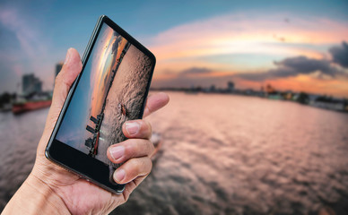 Hand holding smartphone landscape nature background