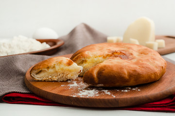 Cottage cheese traditional Russian pie with ingredients. Home cooking food photography in warm tones.