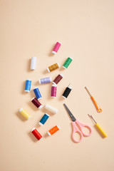 Fototapeta na wymiar tools for needlework thread scissors and tape measure isolated on biege background