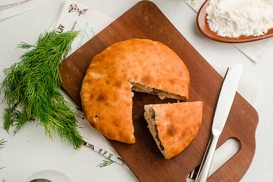 Savory traditional Russian pie with meat and dill. Showing ingredients. Home cooking food photography in warm tones.