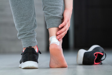 Using medical adhesive plaster from calluses during wearing a new shoe. Skin care and prevention of corns