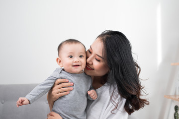 happy family at home. Mother holding baby daughter in living room in cozy weekend morning