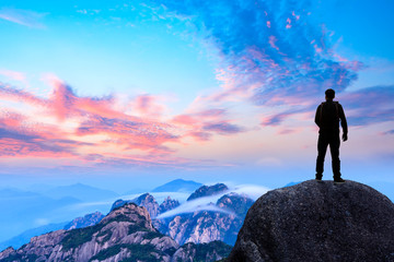 Fototapeta premium Young happy backpacker on top of a mountain enjoying valley view