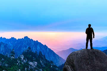 Fototapeta premium Young happy backpacker on top of a mountain enjoying valley view