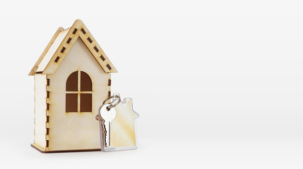 Wooden house model and a key on a keychain. Light background with copyspace