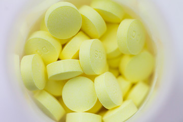 Fototapeta na wymiar yellow pills on white background