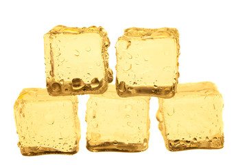 Golden ice cubes on white background.