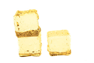 Golden ice cubes on white background.