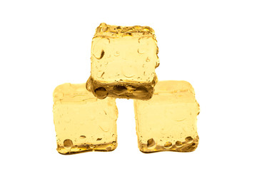 Golden ice cubes on white background.