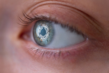 Woman's eye with smart contact lens with digital and biometric implants to scan the ocular retina...