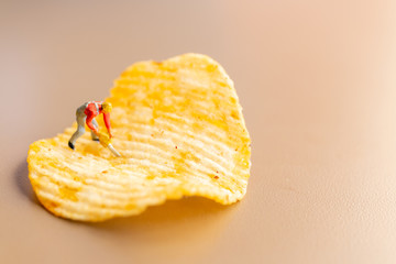 Miniature people : Worker are working with potato chips 