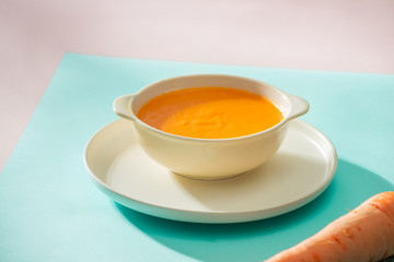 Carrot baby puree in bowl isolated on light background