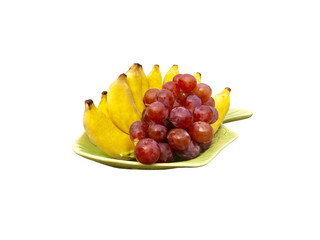 Red grape and banana decoration on dish isolated on white background