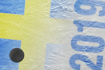 Puck and the image of the Swedish flag on the ice hockey arena