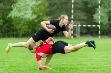 Girls playing rugbyl together outside in summer