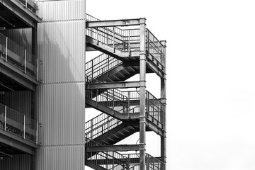 empty external metal fire escape stairs construction out side of modern building with copy space. black and white color