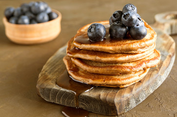 Chocolate pancakes with blueberries on a dark background.