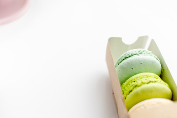 Assorted macaroons in craft paper box flat lay.white table background. top view Copyspace horizontal