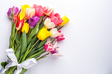 bright spring bouquet of multi-colored tulips on a white background
