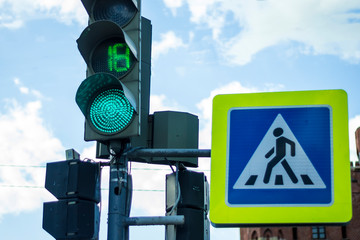 traffic light with green on blue sky background pedestrian crossing sign