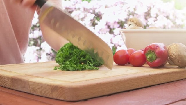 Cutting fresh parsley and vegetables