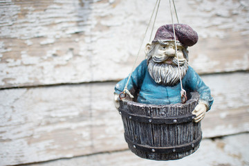 figure garden gnome hanging on a wooden house